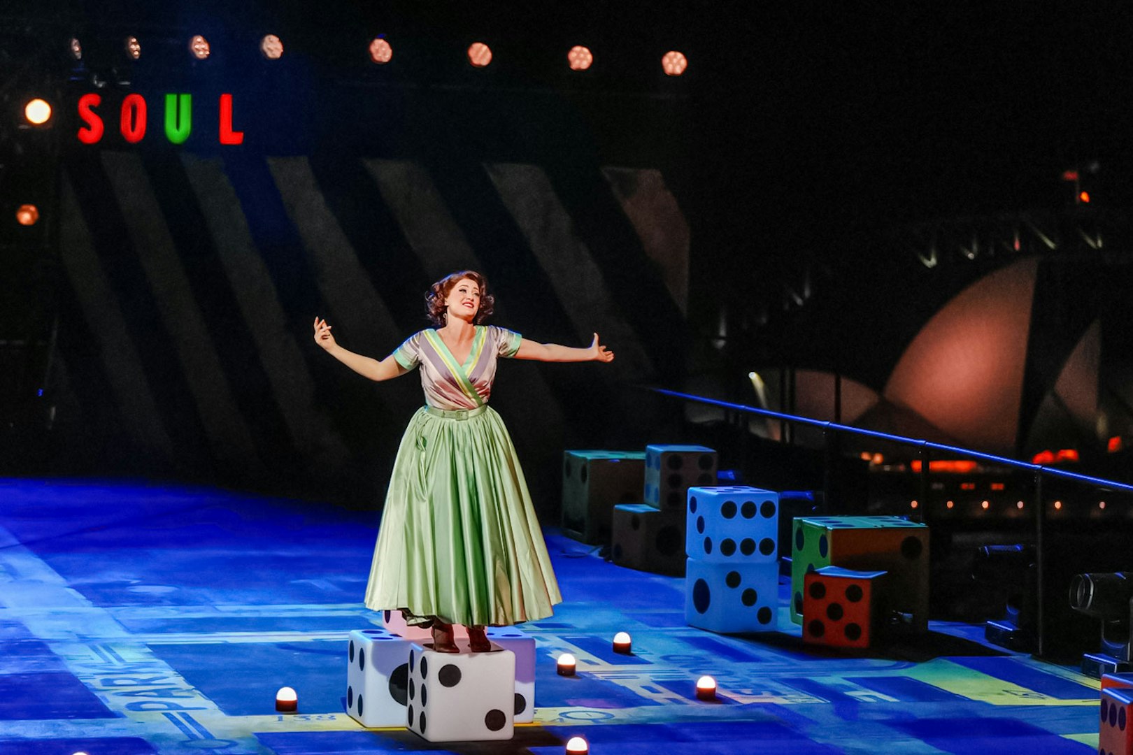 Performer on stage during "Guys & Dolls" at Sydney Harbour with Sydney Opera House in background.