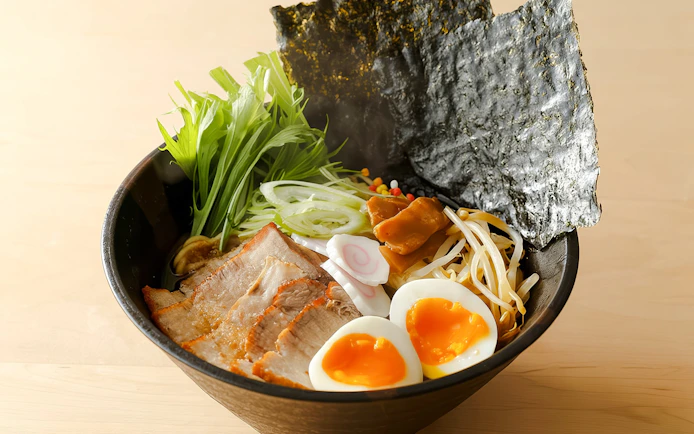Bowl of ramen with pork, soft-boiled eggs, seaweed, and vegetables at Tokyo cooking class.