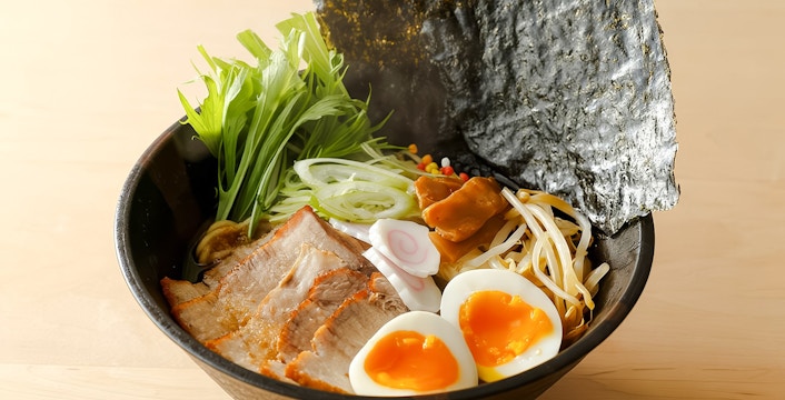 Bowl of ramen with pork, soft-boiled eggs, seaweed, and vegetables at Tokyo cooking class.