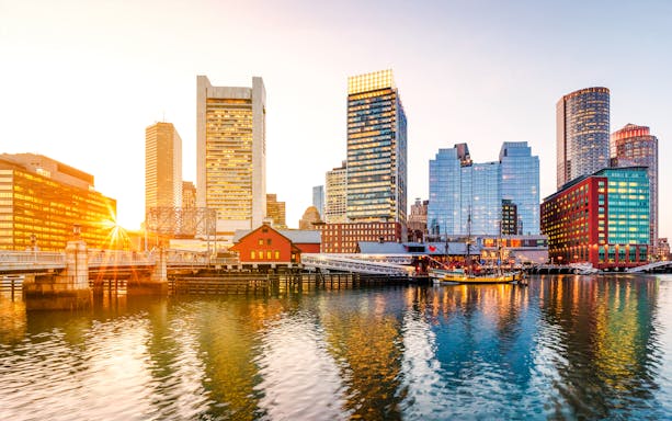 Boston Harbor and Financial District skyline at sunset, Massachusetts, USA.