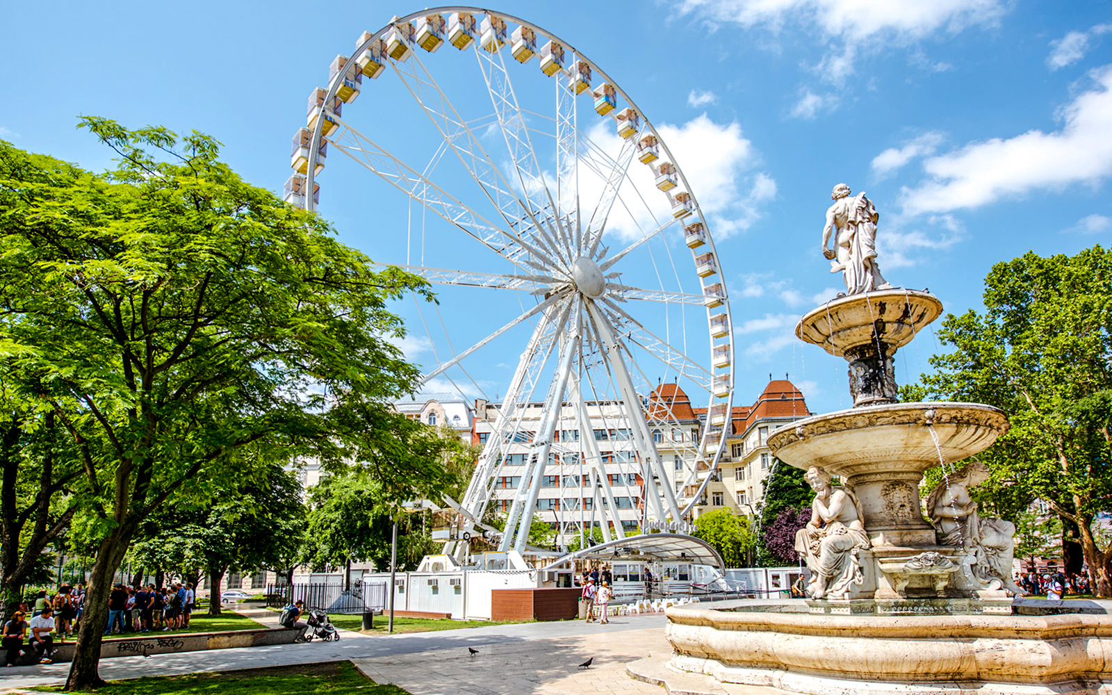 Ferris Wheel of Budapest with nearby fountain and park setting.