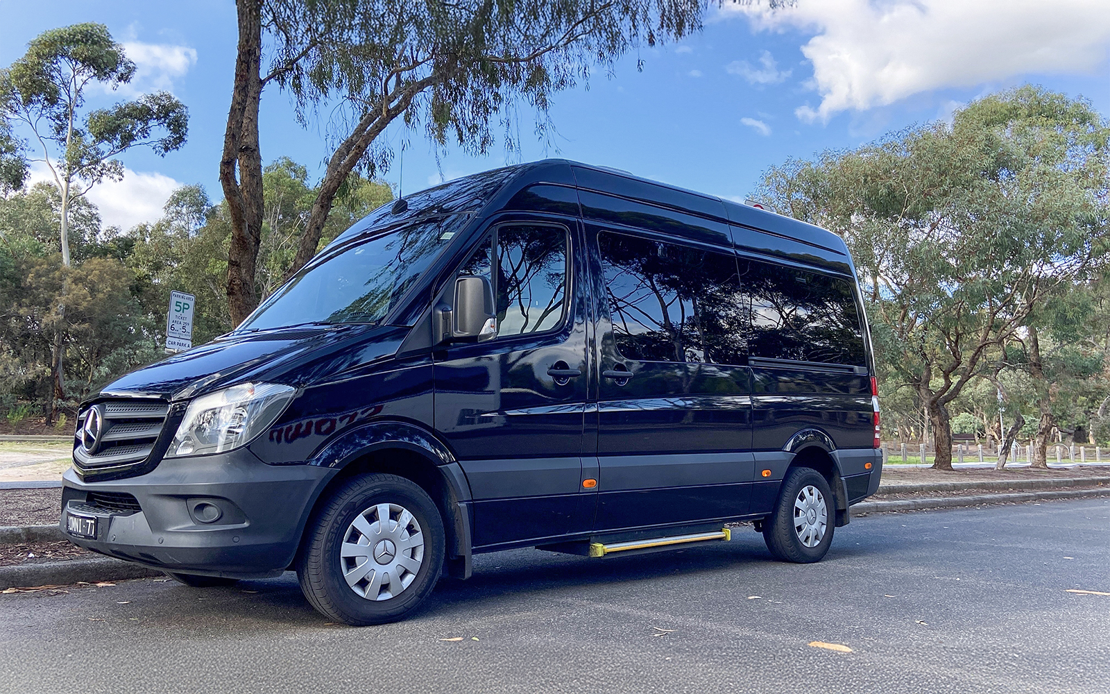 Tour van parked on a tree-lined street for Sports Lovers Day Tour, Melbourne.