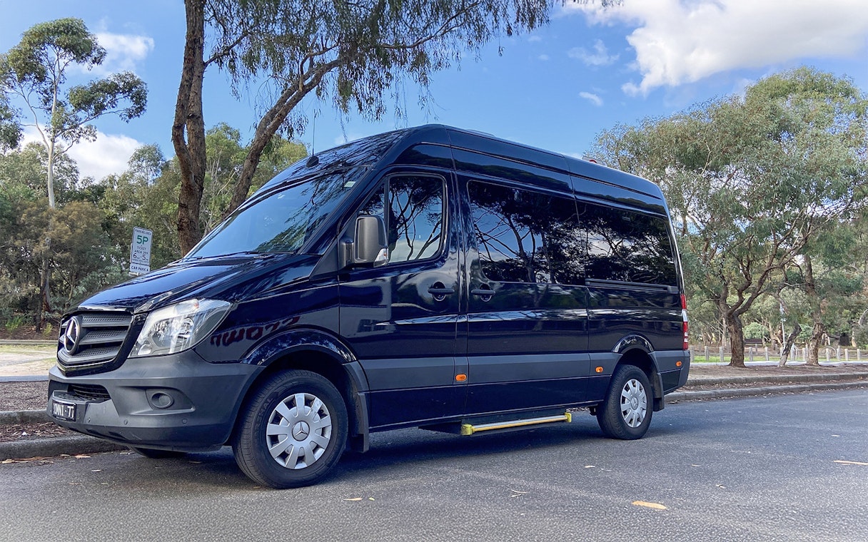 Tour van parked on a tree-lined street for Sports Lovers Day Tour, Melbourne.