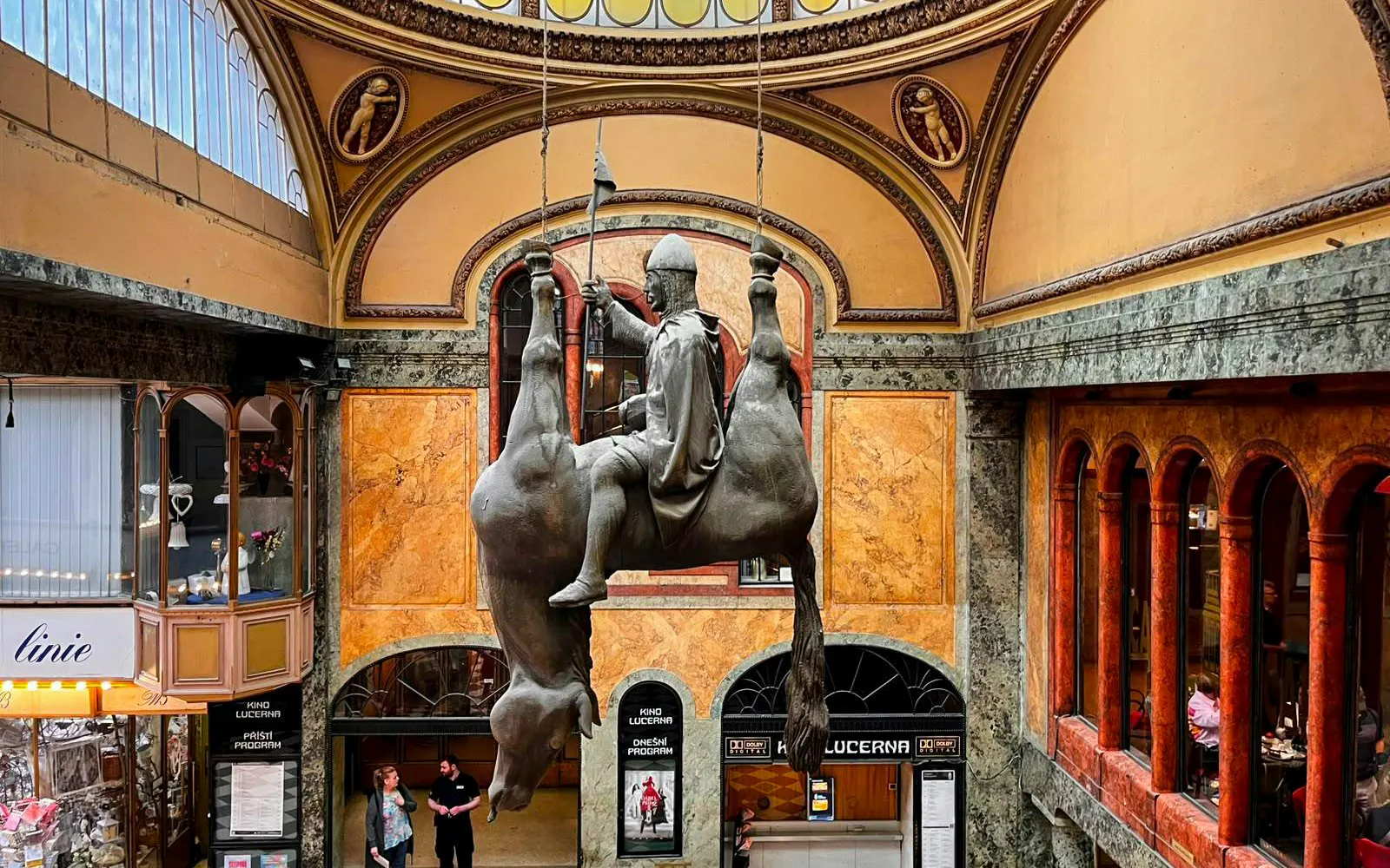 Statue of a rider on an upside-down horse in Lucerna Palace, Prague.