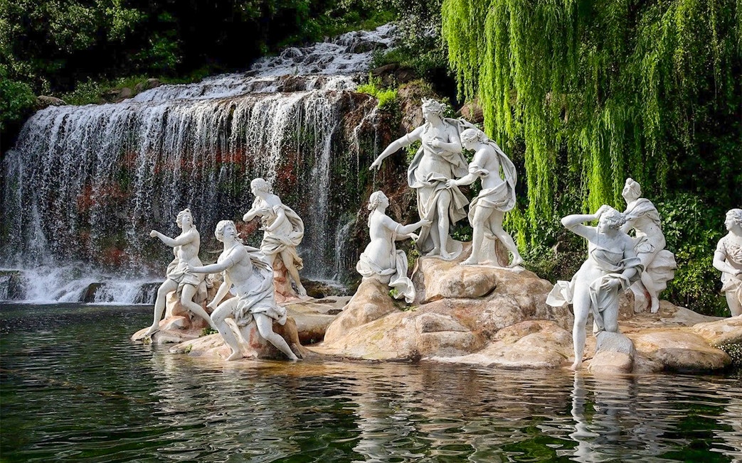 Statues near waterfall at Royal Palace of Caserta gardens.
