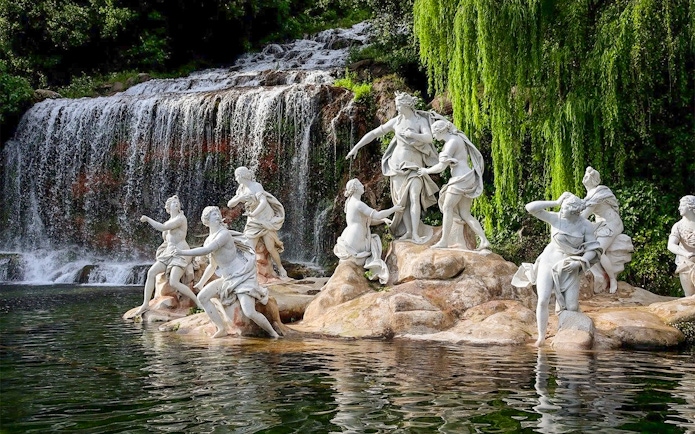 Statues near waterfall at Royal Palace of Caserta gardens.