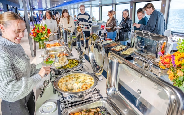 Buffet dining on a Chicago River cruise with passengers serving themselves.