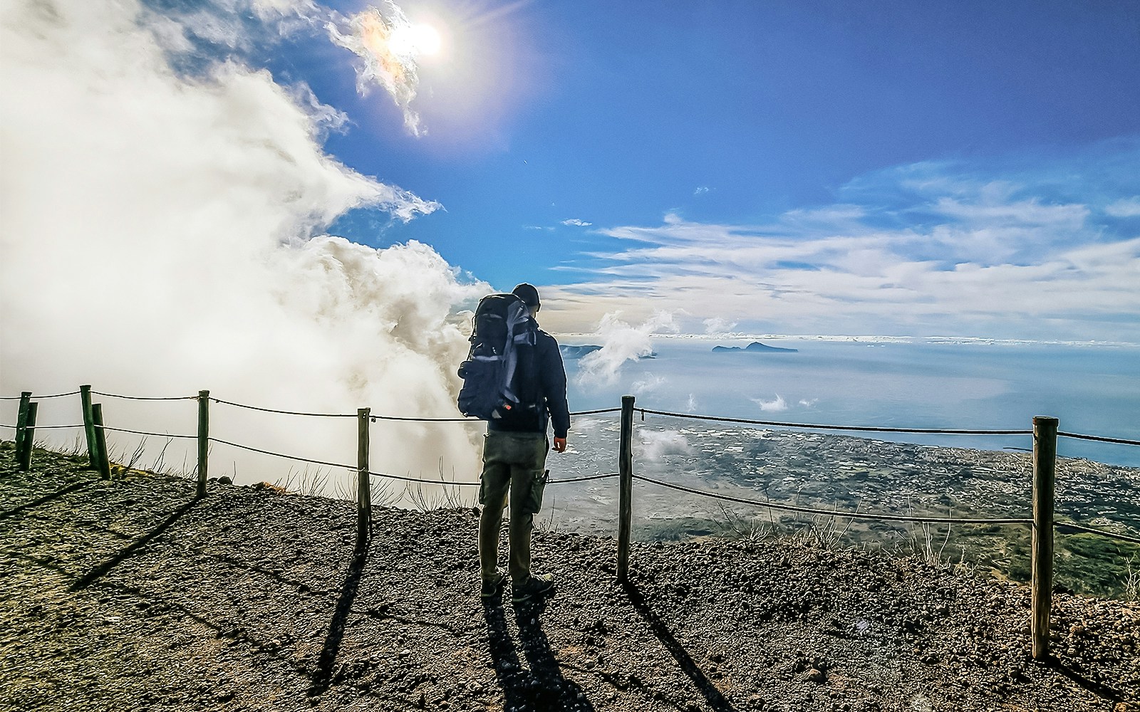 Hiker overlooking the view from Mount Vesuvius summit, Italy.