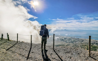 Hiker overlooking the view from Mount Vesuvius summit, Italy.