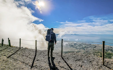 Hiker overlooking the view from Mount Vesuvius summit, Italy.
