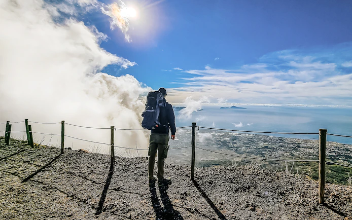 Hiker overlooking the view from Mount Vesuvius summit, Italy.