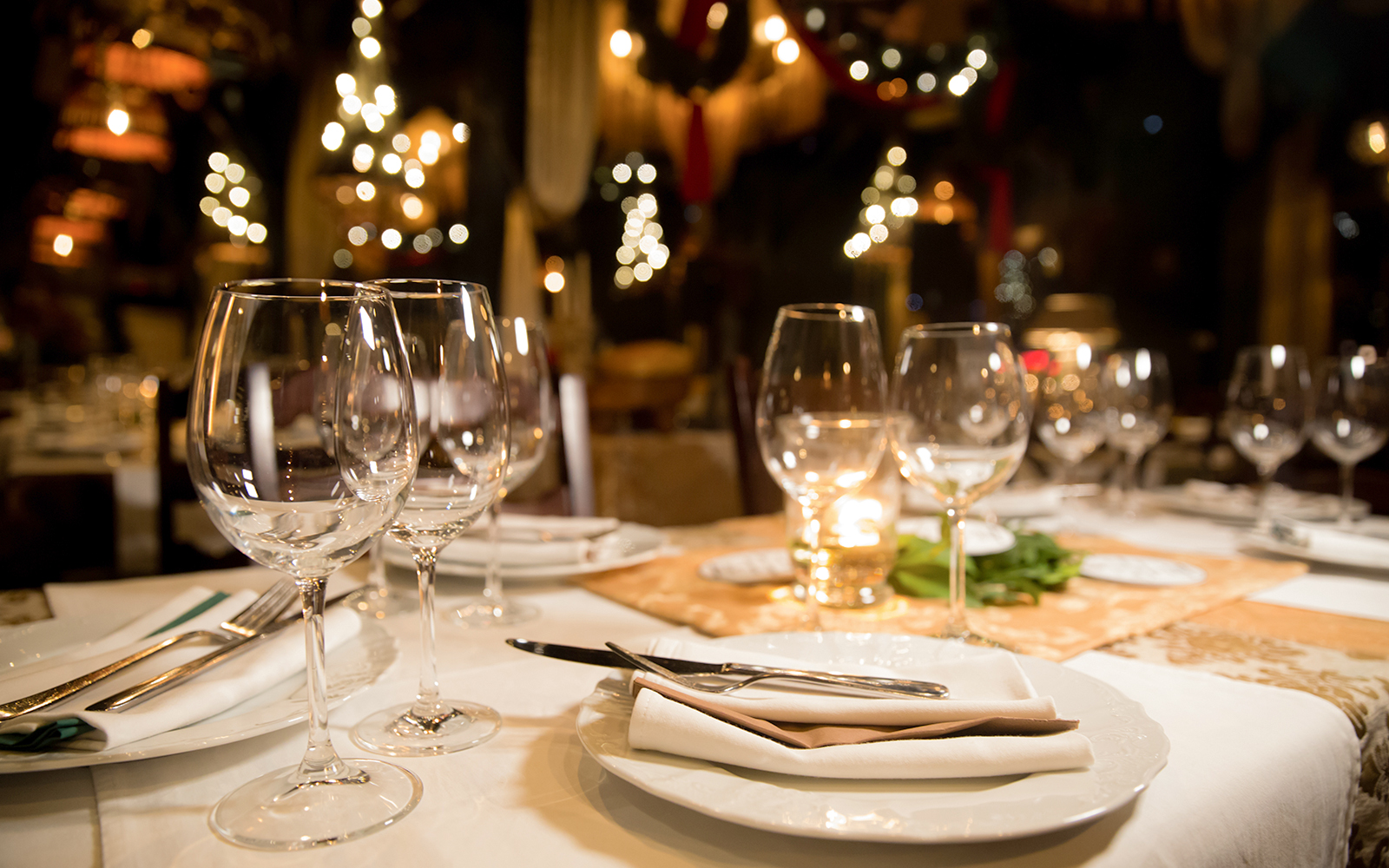 Fine dining table set with wine glasses and warm lighting in a cozy restaurant.