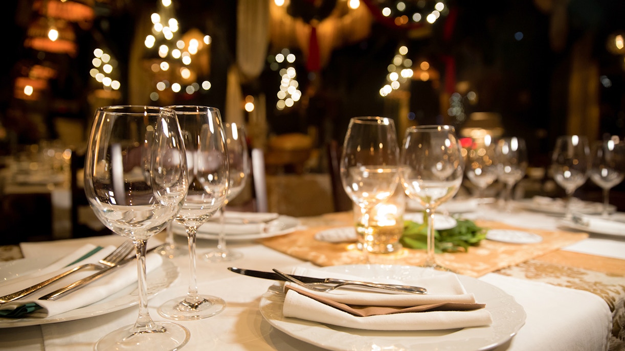 Fine dining table set with wine glasses and warm lighting in a cozy restaurant.