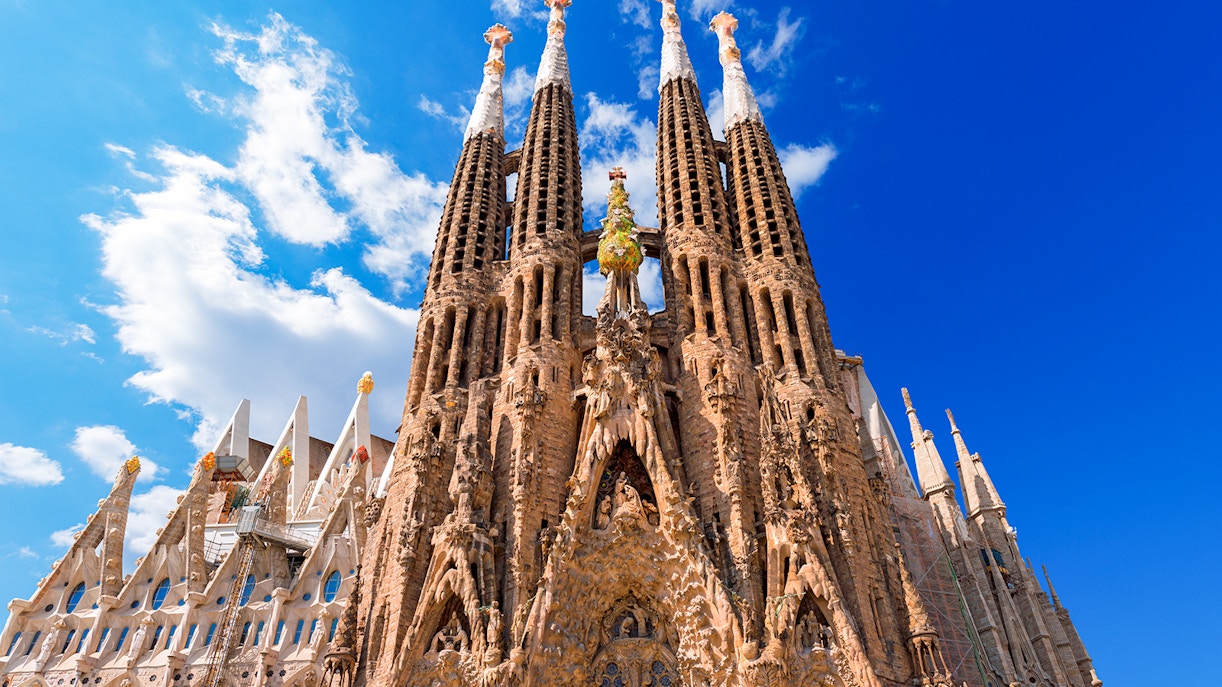 Sagrada Familia's intricate facade under a clear blue sky in Barcelona.