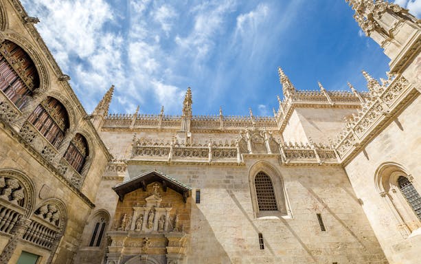 Granada Royal Chapel exterior with ornate Gothic architecture under a blue sky.