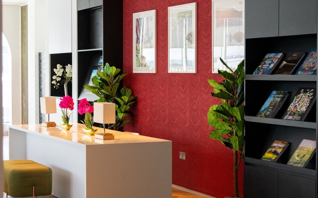 Plaza Premium Lounge seating area with plants and bookshelves, London Gatwick Airport.