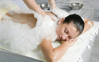 Person receiving a foamy massage in a traditional Moroccan hammam, Marrakech.