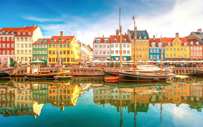 Colorful buildings and boats along Nyhavn canal in Copenhagen, Denmark.