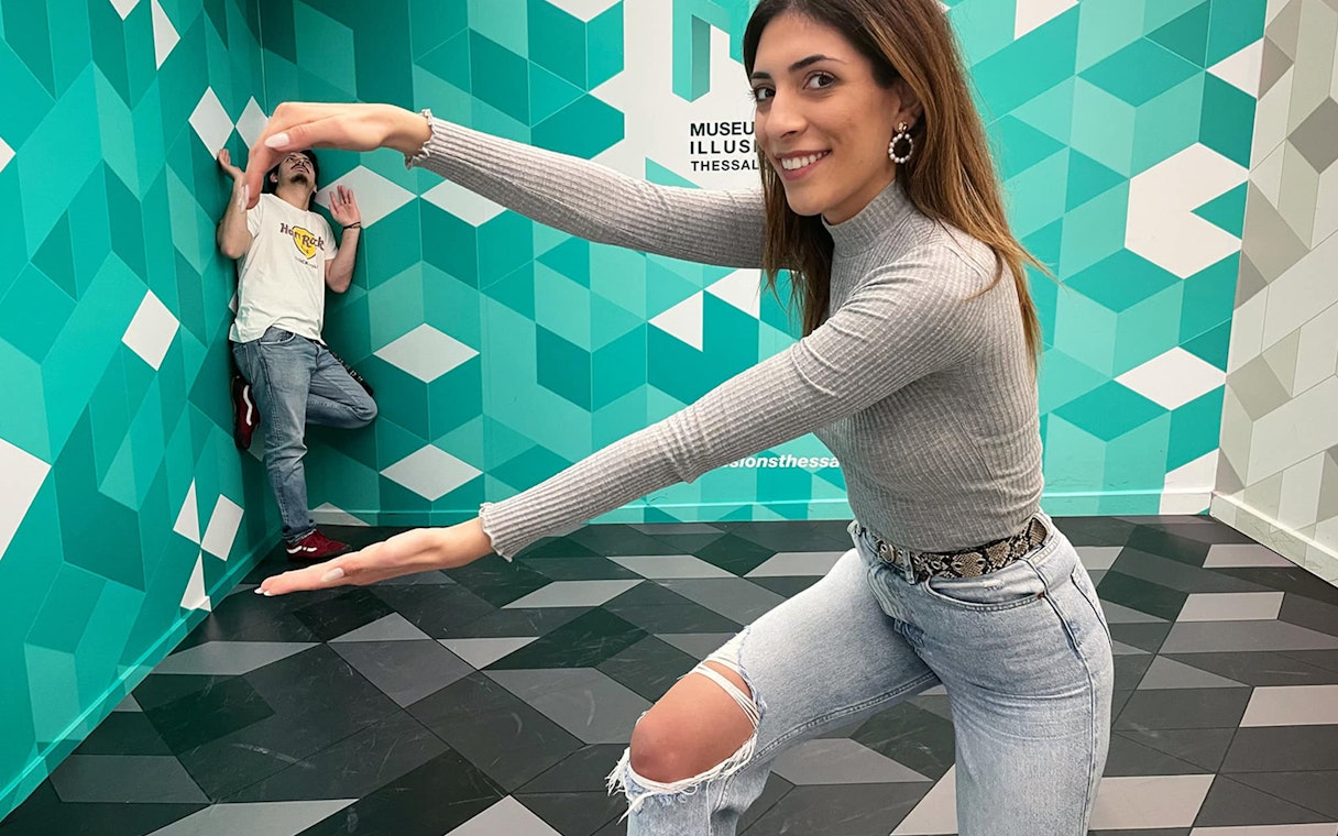 Visitors interacting with an optical illusion at the Museum of Illusions in Thessaloniki.