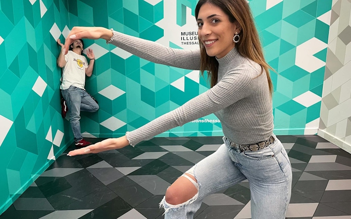 Visitors interacting with an optical illusion at the Museum of Illusions in Thessaloniki.