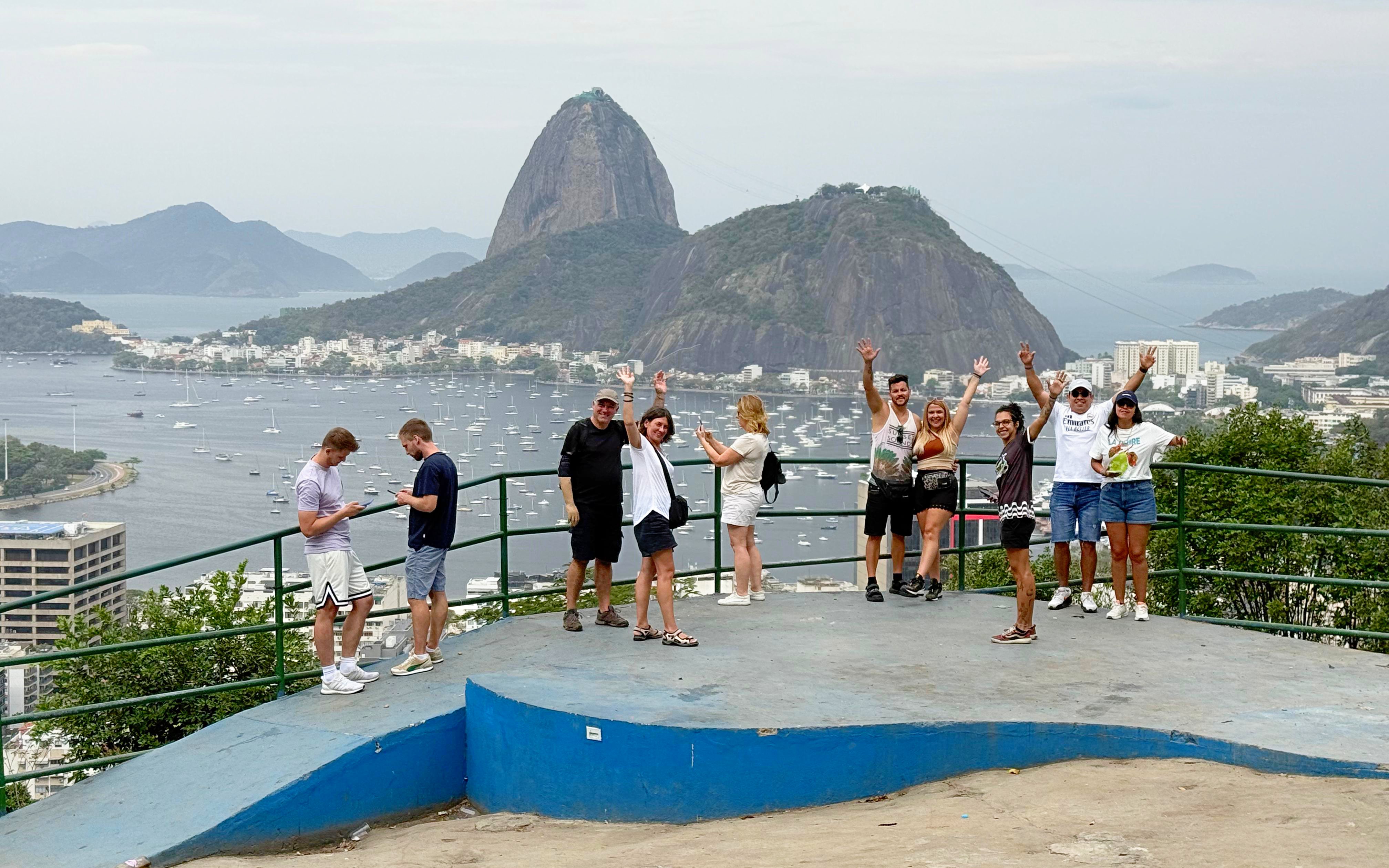 Tourists with guide at viewpoint overlooking Sugarloaf Mountain in Santa Marta, Rio de Janeiro.