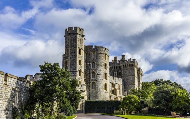 Windsor hop-on hop-off bus tour passing Windsor Castle with tourists exploring.