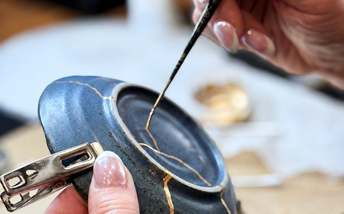 Repairing pottery with gold lacquer at Kintsugi workshop in Shibuya.