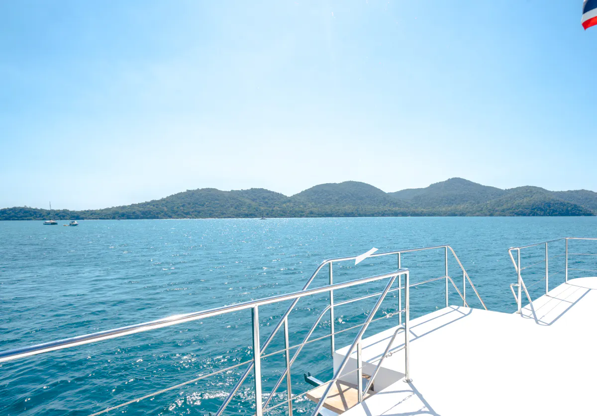 Luxury yacht deck overlooking islands and blue sea, Pattaya cruise.