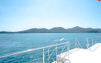 Luxury yacht deck overlooking islands and blue sea, Pattaya cruise.