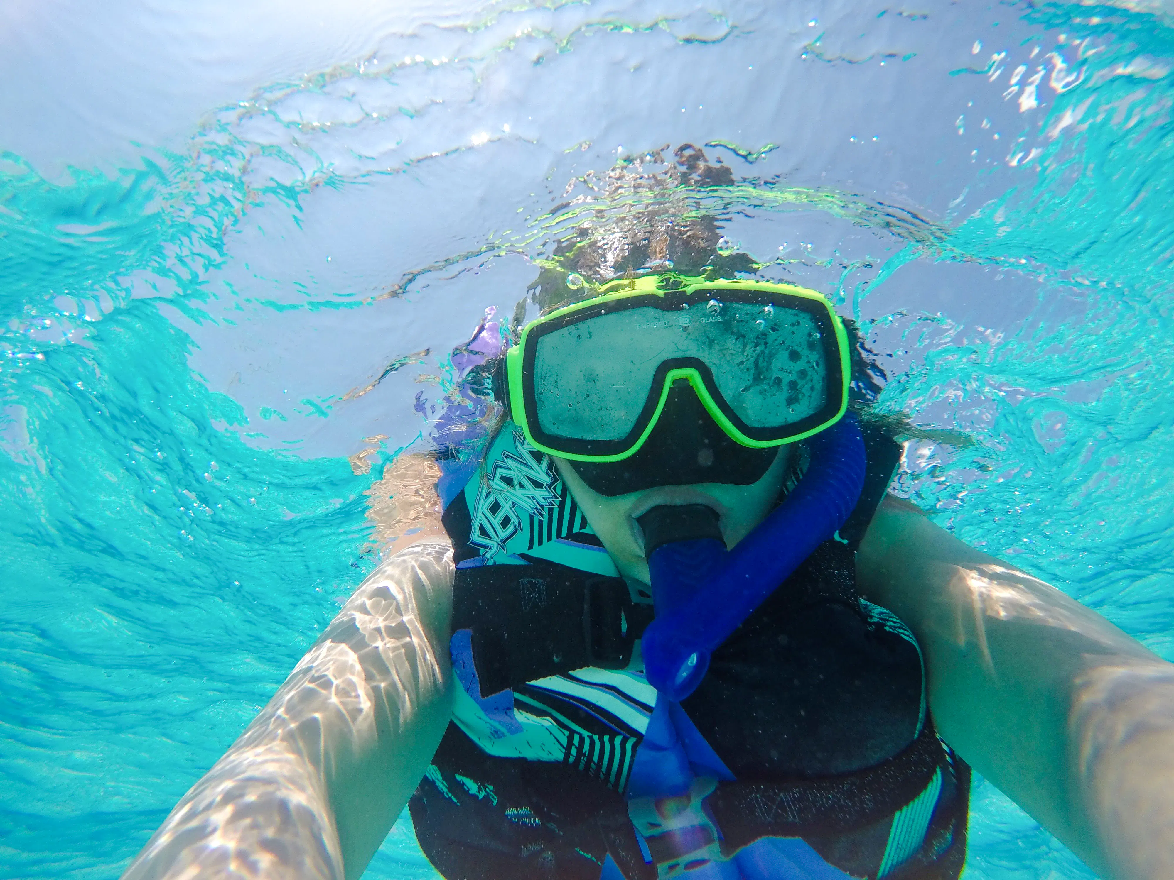 Snorkeler in clear waters of Mnemba Island Atoll, Zanzibar.