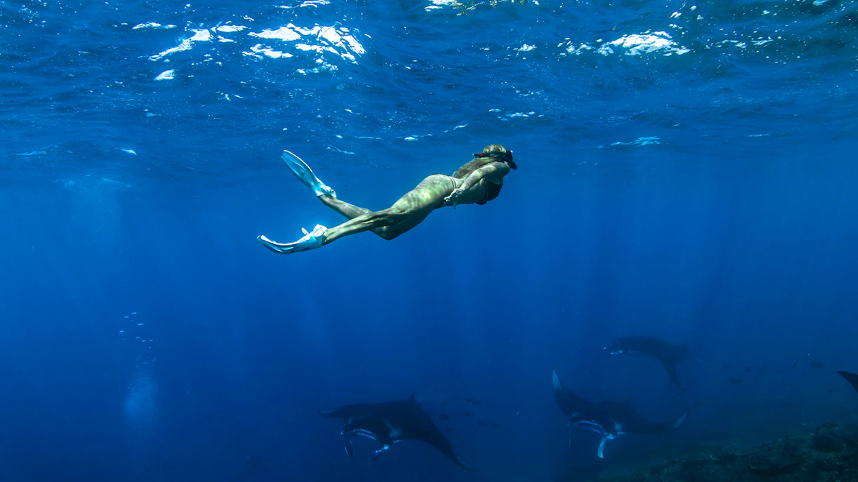 Girl snorkeling among marine life at Nusa Penida Manta Point, Indonesia.