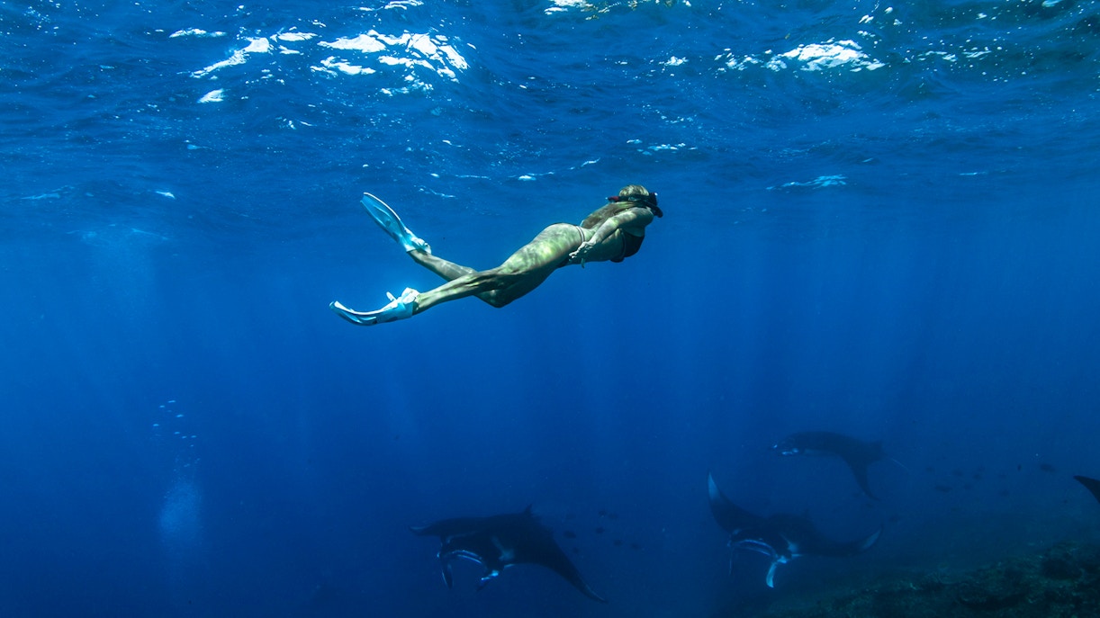 Girl snorkeling among marine life at Nusa Penida Manta Point, Indonesia.