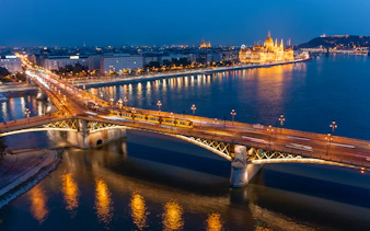 Margaret Bridge over Danube River in Budapest with illuminated cityscape at night.