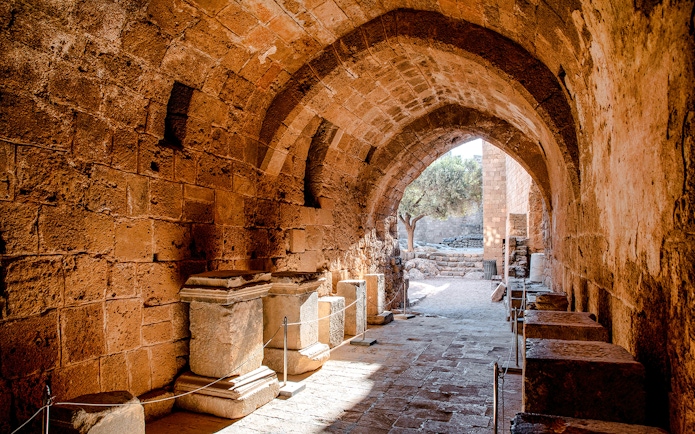 Ancient stone archway and ruins at Lindos Acropolis, Rhodes, Greece.