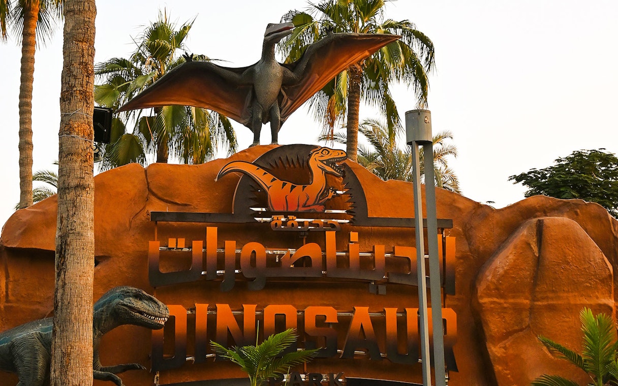 Dinosaur Park entrance sign with pterodactyl statue at Dubai Garden Glow.