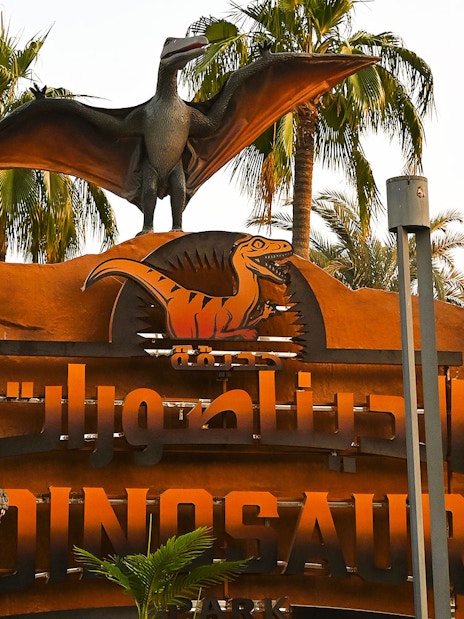 Dinosaur Park entrance sign with pterodactyl statue at Dubai Garden Glow.