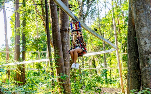 Person ziplining through forest on Sky Rock Roller Adventure in Khao Lak.