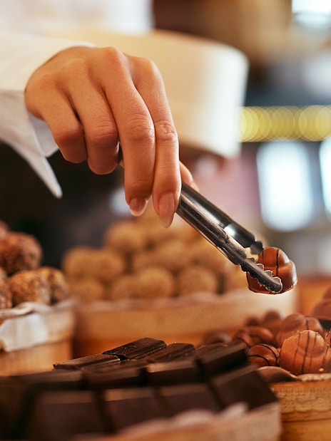 Hand selecting chocolates at Chocolate Museum Cologne.
