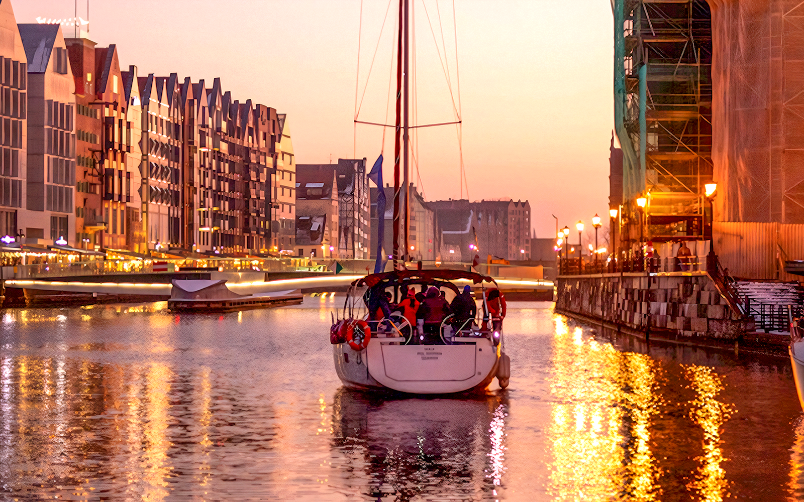 Sunset cruise boat on Gdansk River with historic buildings in the background.