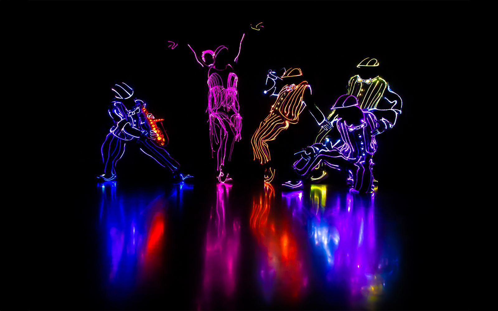 Performers in illuminated costumes dancing in an iLuminate show.