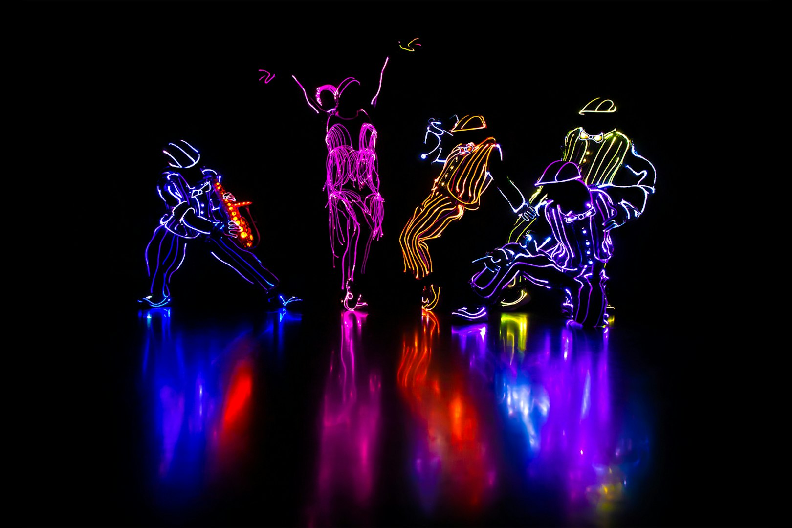 Performers in illuminated costumes dancing in an iLuminate show.
