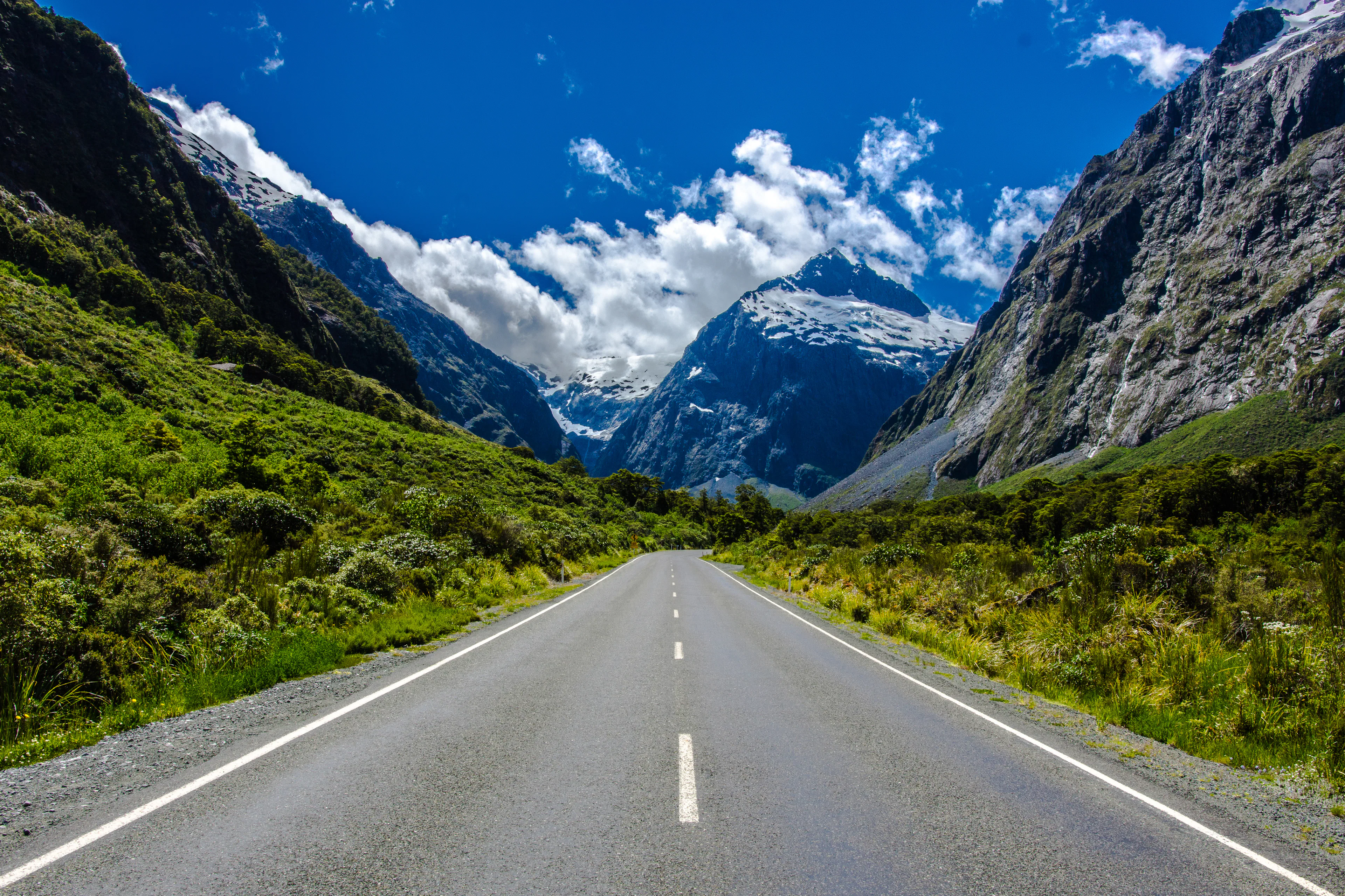 Milford Road with mountains and lush greenery in New Zealand.