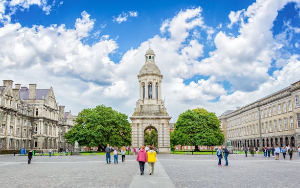 Trinity College Dublin courtyard with bell tower and visitors.
