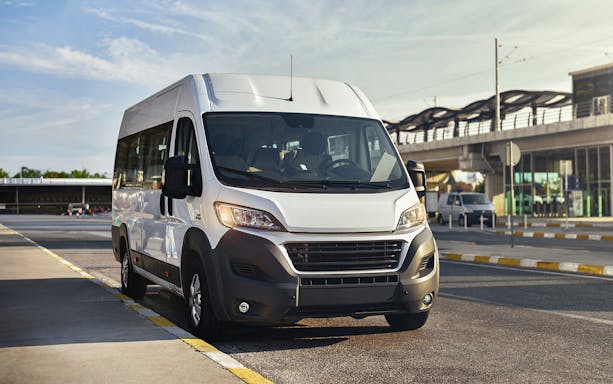 Airport transfer shuttle parked outside terminal.