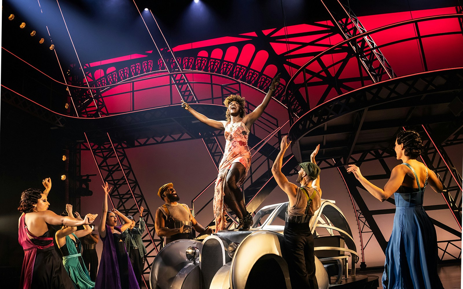 Performer on stage with art deco backdrop in Lempicka-themed show.