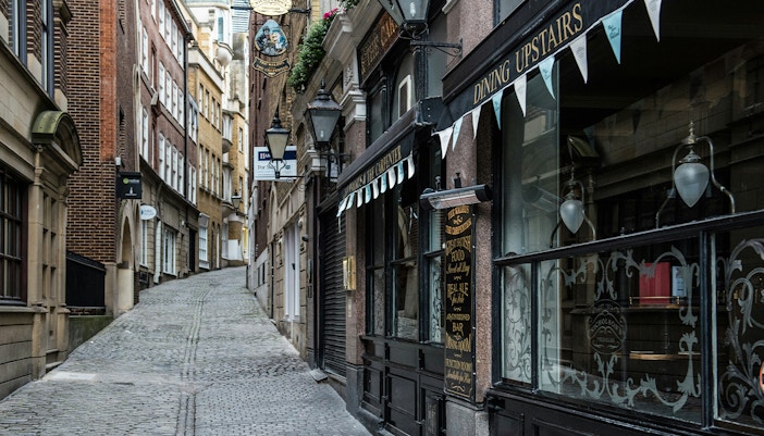 Narrow cobblestone street in London resembling Diagon Alley from Harry Potter.