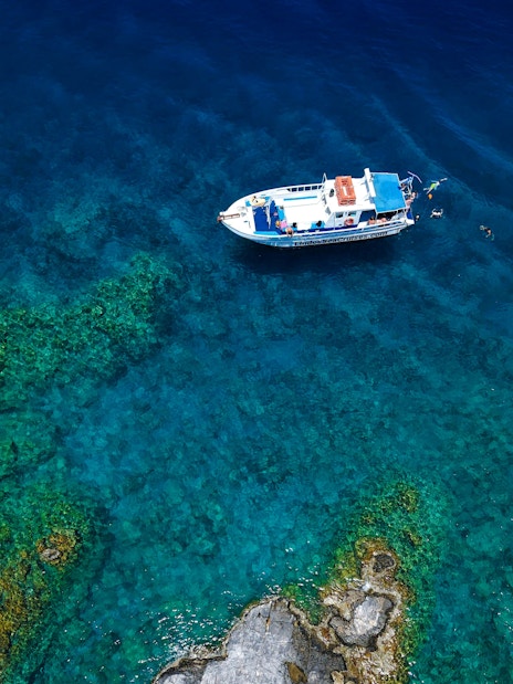 Boat on turquoise sea during Lindos Sunset Cruise, Greece.