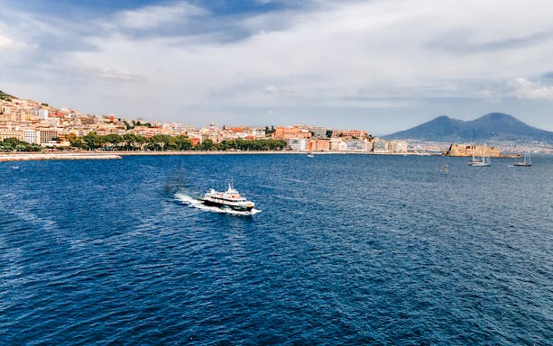 Ferry crossing the Gulf of Naples with Mount Vesuvius in the background.