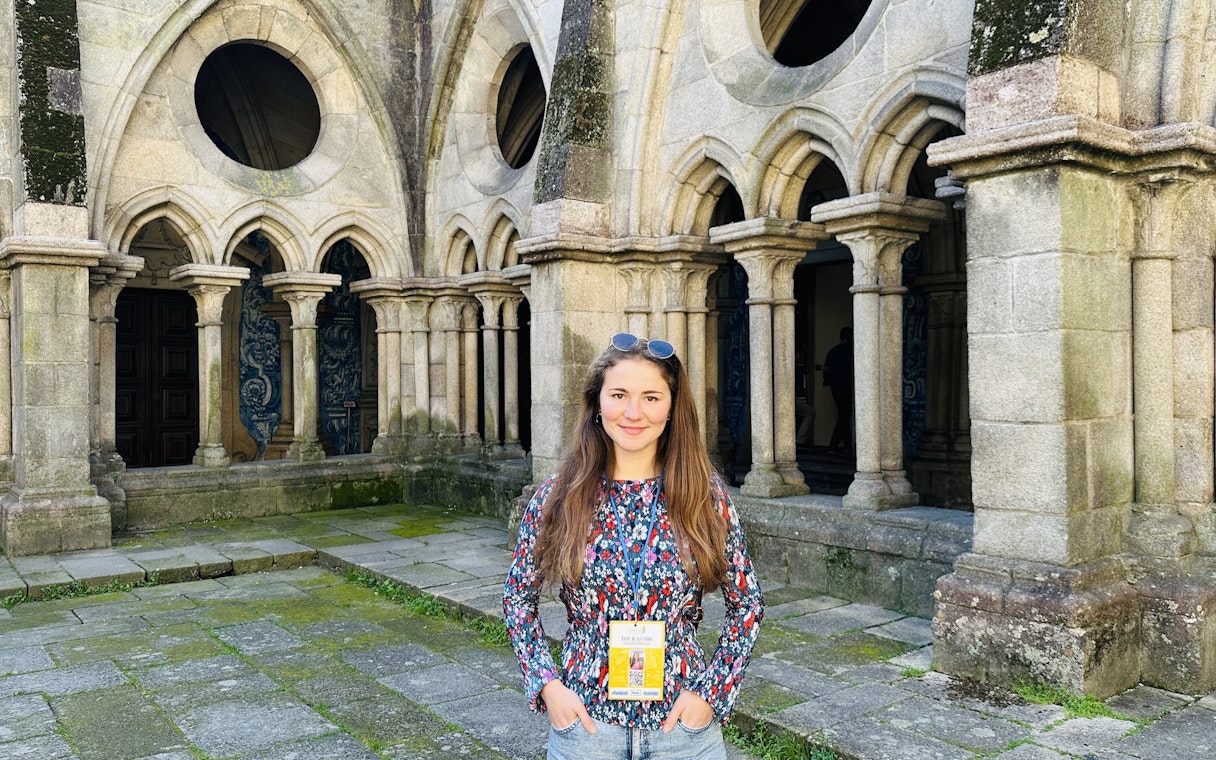 Guide standing inside the Porto Cathedral near stone arches.