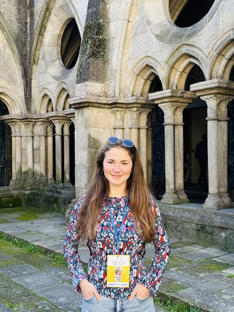Guide standing inside the Porto Cathedral near stone arches.